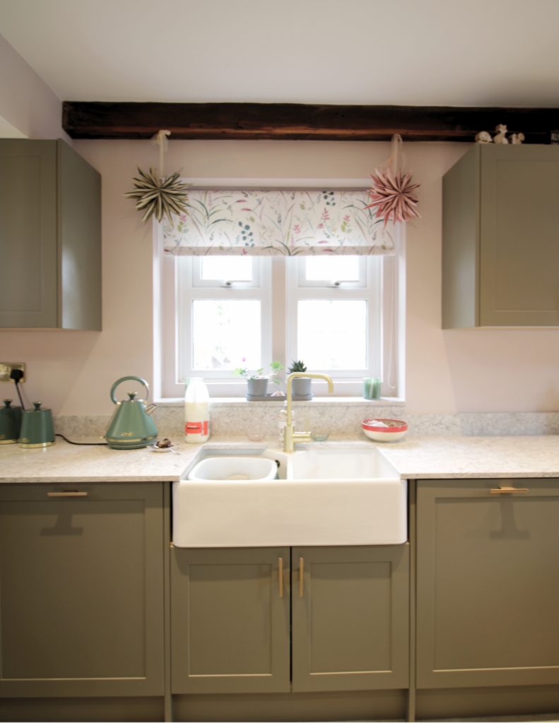 Sage green cabinets and a white butler sink installed as part of a kitchen renovation in Stalybridge, Cheshire.