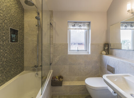 Grey tiled family bathroom